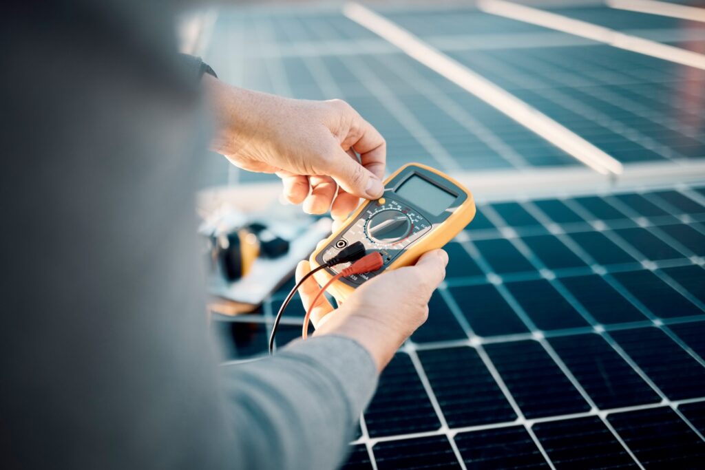 Solar panels, multimeter and engineering hands for voltage check, installation or maintenance. Sust